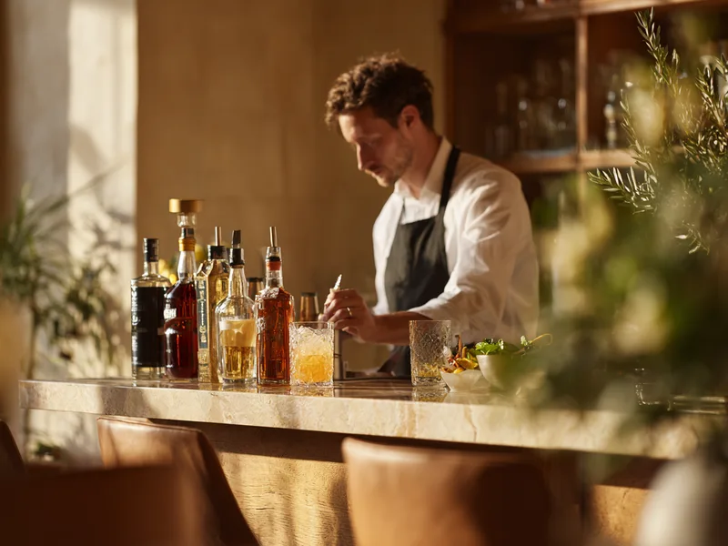 Cocktail wird hinter einer Hotelbar zubereitet