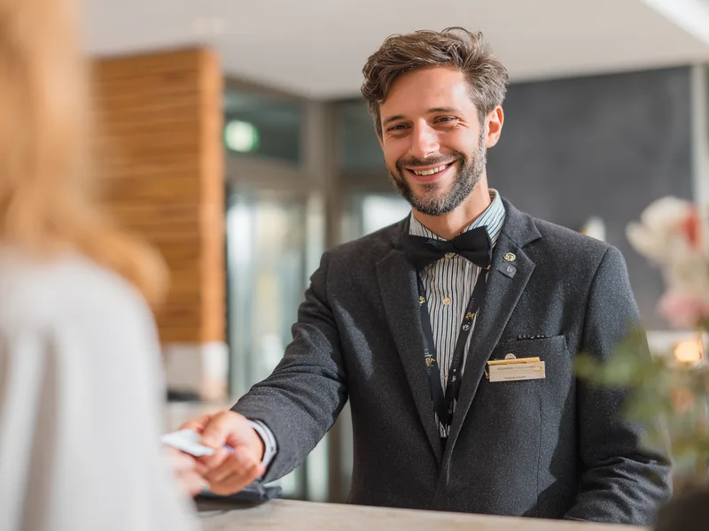 Rezeptionist übergibt die Zimmerkarte beim Check-in